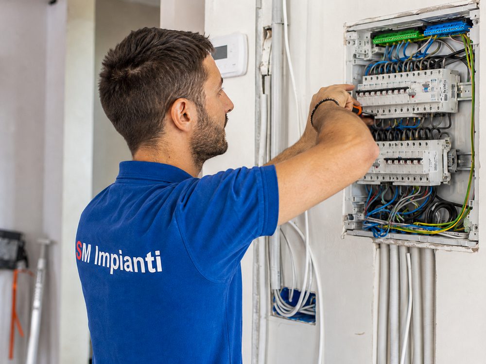 Tecnico SM Impianti al lavoro su un quadro elettrico